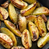 Patate al forno dorate e croccanti, condite con rosmarino e aglio, pronte per essere gustate.