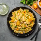 Piatto di pasta con pesce spada, pomodorini gialli e prezzemolo fresco. Un classico sapore mediterraneo.