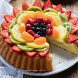Una deliziosa crostata di frutta, con fragole, kiwi, mandarini, lamponi e mirtilli su una base di crema pasticcera.