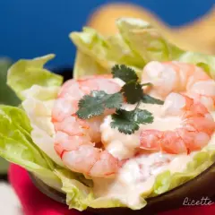 Gamberetti succulenti in salsa rosa cremosa, serviti su foglie di lattuga croccante. Un antipasto fresco e invitante.