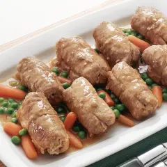 Sette involtini di carne succulenti in un piatto bianco con piselli e carote.