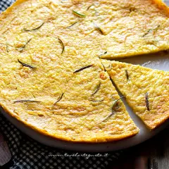 Farinata di ceci dorata e profumata al rosmarino, appena sfornata e tagliata a spicchi, pronta per essere gustata.