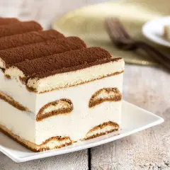 Tiramisù cremoso e soffice, un dolce senza glutine perfetto per ogni occasione. Strati di savoiardi senza glutine e crema al mascarpone, spolverato di cacao.