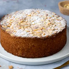 Torta rustica con farina di mandorle, guarnita con pinoli e zucchero a velo. Perfetta per ogni occasione.