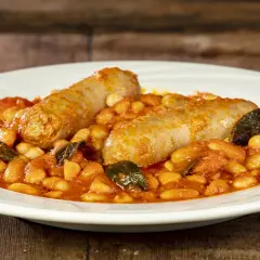 Salsiccia e fagioli in umido, un piatto rustico e saporito, servito su un piatto bianco.