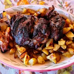 Un succulento agnello al forno con patate croccanti, un piatto che profuma di tradizione e famiglia.