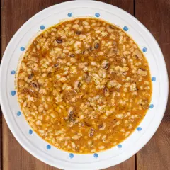 Piatto di riso e fagioli, un classico confortante, servito in una ciotola bianca con decorazioni blu su un tavolo di legno.