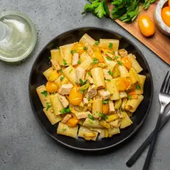 Piatto di pasta con pesce spada, pomodorini gialli e prezzemolo fresco. Un classico sapore mediterraneo.