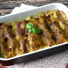 Cannelloni ricotta e spinaci appena sfornati, dorati e profumati, guarniti con una fogliolina di basilico fresco.