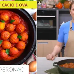 Pallotte cacio e ova in sugo rosso, pronte per essere gustate. Una donna in cucina prepara questo piatto tradizionale.