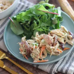 Deliziosa insalata di pollo con carote, sedano e un tocco di erbe fresche, servita con un contorno di insalata mista.