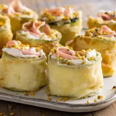 Rotolini di zucchine fritte con crema, prosciutto e pistacchi: stuzzichini veloci ed economici per aperitivo.