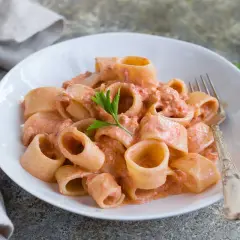 Un piatto invitante di pasta al tonno con una cremosa salsa rosa, guarnito con prezzemolo fresco.