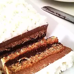 Deliziosa bavarese al cioccolato con strati di pan di Spagna e crema al cacao, guarnita con panna montata.