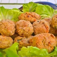 Polpette di melanzane dorate e croccanti, servite su un letto di lattuga fresca. Un antipasto gustoso e leggero.