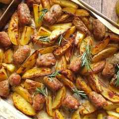 Salsiccia e patate al forno, dorate e profumate al rosmarino, pronte per essere gustate.