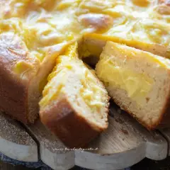 Torta al limone velocissima con crema gialla e soffice impasto, tagliata a fette su un tagliere di legno.