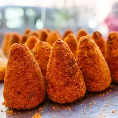 Arancini dorati e croccanti, un classico street food siciliano. Perfetti per uno spuntino goloso.
