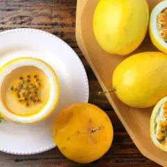 Deliziosa mousse al limone servita in un frutto della passione, guarnita con menta. Frutti della passione freschi completano la scena.
