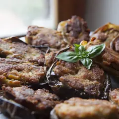 Melanzane ripiene calabresi dorate e gustose, guarnite con basilico fresco. Un piatto tradizionale che profuma di casa.