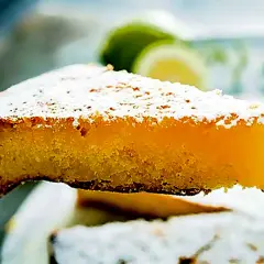 Una fetta di caprese al limone, soffice e profumata, cosparsa di zucchero a velo.