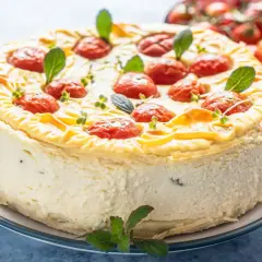 Cheesecake salata con taralli, decorata con pomodorini confit e basilico. Un'idea sfiziosa per un aperitivo o antipasto.