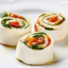 Rotolini di sfoglia di mozzarella come riempirla con pomodori secchi e basilico, conditi con olio.