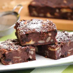 Fette di torta di pane al cioccolato, ricche di frutta secca e mandorle, spolverate di zucchero a velo.