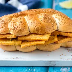 Pane morbido con semi di sesamo farcito con fette dorate di pane e panelle, un classico street food siciliano.