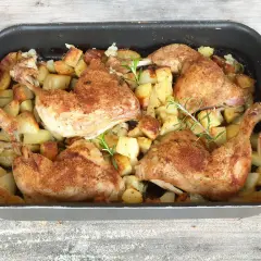Succulento pollo al forno con patate dorate e rosmarino, pronto per essere gustato.