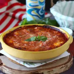 Gnocchi alla sorrentina appena sfornati, dorati e filanti, con basilico fresco. Un piatto invitante e saporito.