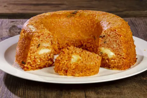 Un invitante timballo di riso, dorato e ripieno di formaggio filante, pronto per essere gustato.