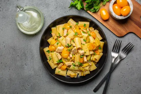 Piatto di pasta con pesce spada, pomodorini gialli e prezzemolo fresco. Un classico sapore mediterraneo.