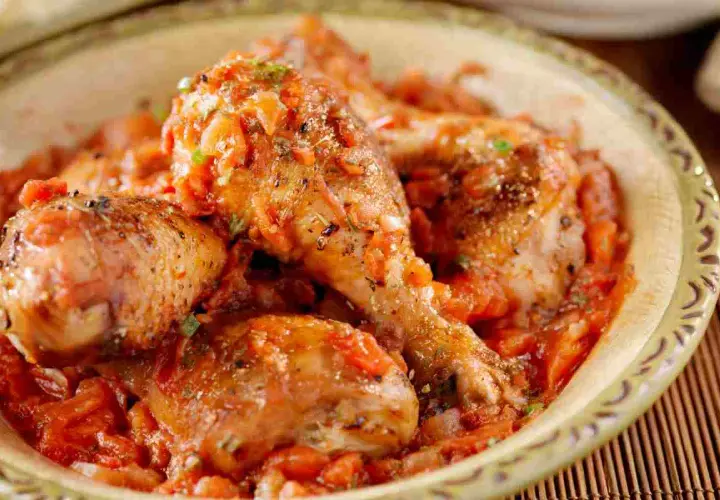 Pollo alla cacciatora succulento in una ciotola, con pezzi di pollo dorati immersi in un sugo rosso ricco di pomodoro e spezie.