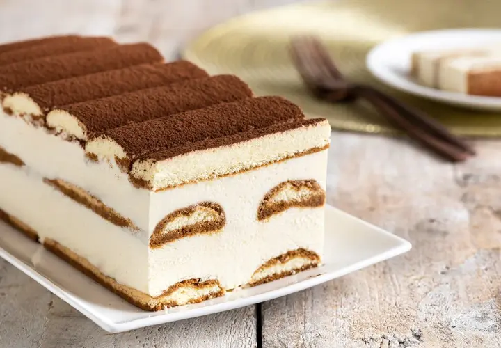 Tiramisù cremoso e soffice, un dolce senza glutine perfetto per ogni occasione. Strati di savoiardi senza glutine e crema al mascarpone, spolverato di cacao.