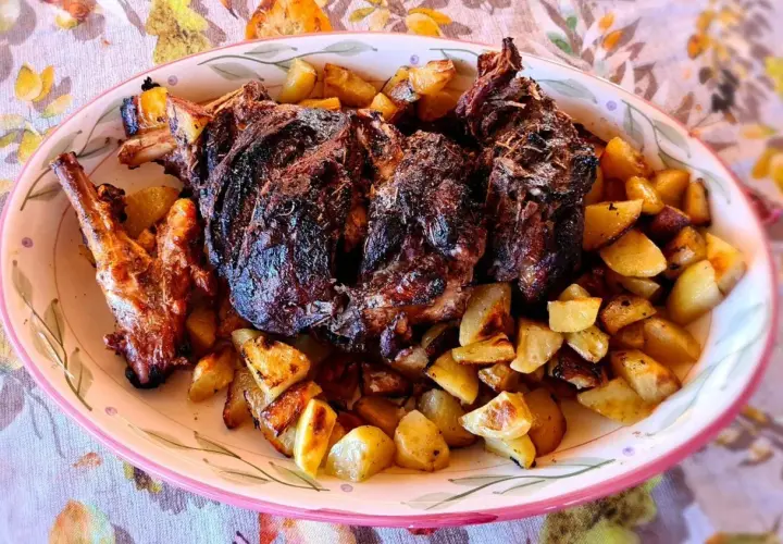 Un succulento agnello al forno con patate croccanti, un piatto che profuma di tradizione e famiglia.