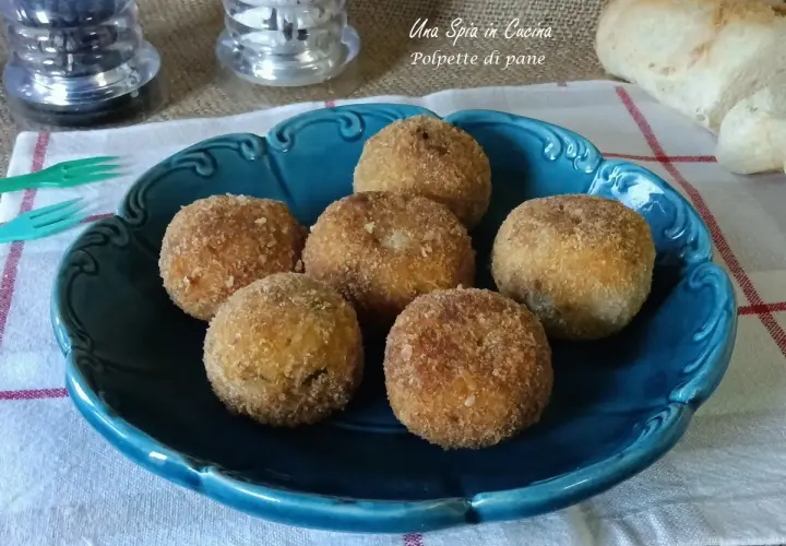Sette polpette di pane dorate e croccanti, servite su un piatto blu. Perfette per uno spuntino gustoso.