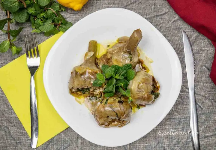 Un piatto invitante di carciofi alla romana, teneri e profumati, guarniti con menta fresca.