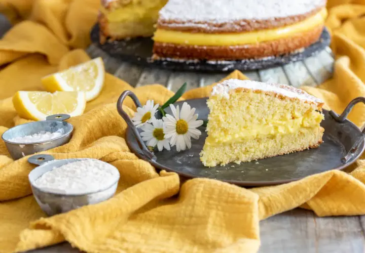 Una fetta di torta paradiso, soffice e farcita di crema, pronta per essere gustata. La ricetta perfetta per un dolce fatto in casa.