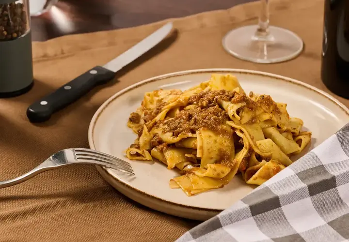 Piatto di pappardelle al cinghiale, un classico della cucina toscana, pronto per essere gustato.