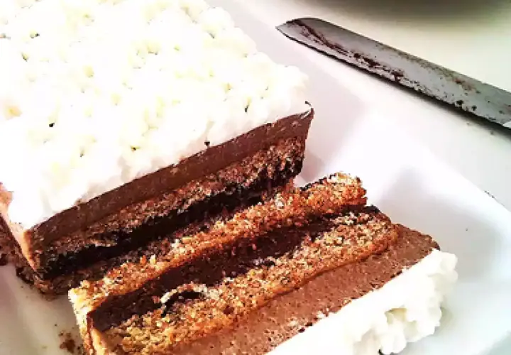 Deliziosa bavarese al cioccolato con strati di pan di Spagna e crema al cacao, guarnita con panna montata.