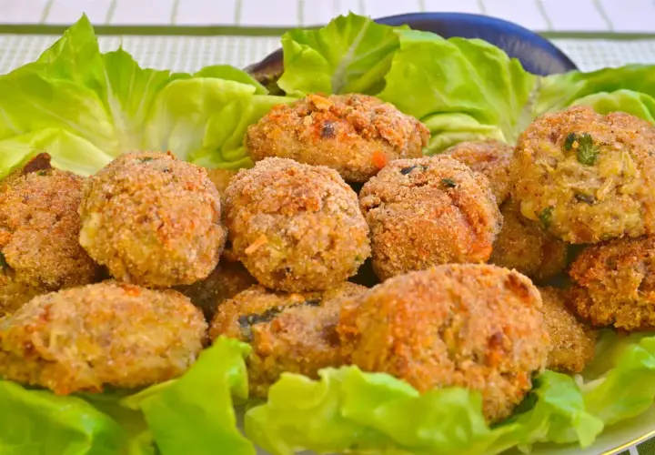 Polpette di melanzane dorate e croccanti, servite su un letto di lattuga fresca. Un antipasto gustoso e leggero.