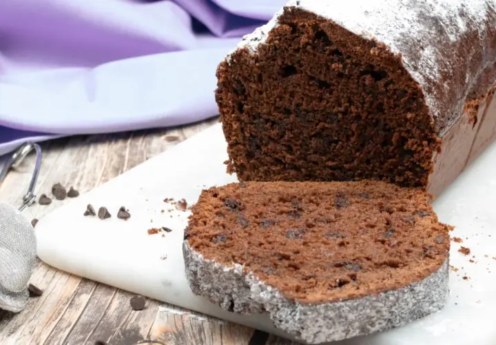 Un soffice plumcake al cioccolato, cosparso di zucchero a velo, pronto per essere gustato.