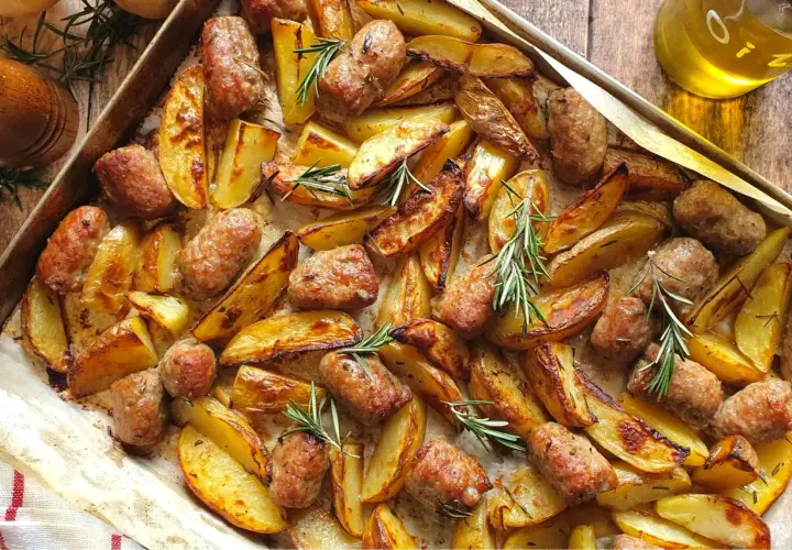 Salsiccia e patate al forno, dorate e profumate al rosmarino, pronte per essere gustate.
