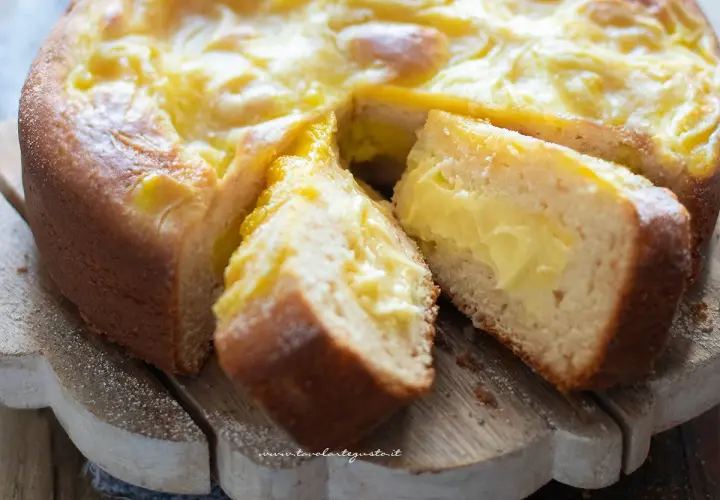 Torta al limone velocissima con crema gialla e soffice impasto, tagliata a fette su un tagliere di legno.