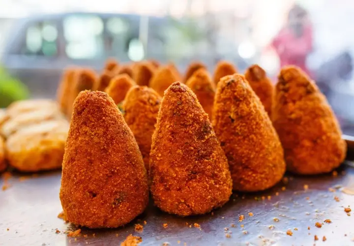 Arancini dorati e croccanti, un classico street food siciliano. Perfetti per uno spuntino goloso.