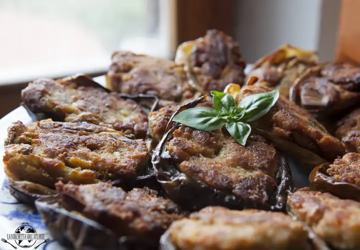 Melanzane ripiene calabresi dorate e gustose, guarnite con basilico fresco. Un piatto tradizionale che profuma di casa.
