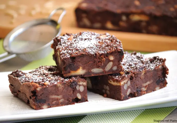 Fette di torta di pane al cioccolato, ricche di frutta secca e mandorle, spolverate di zucchero a velo.
