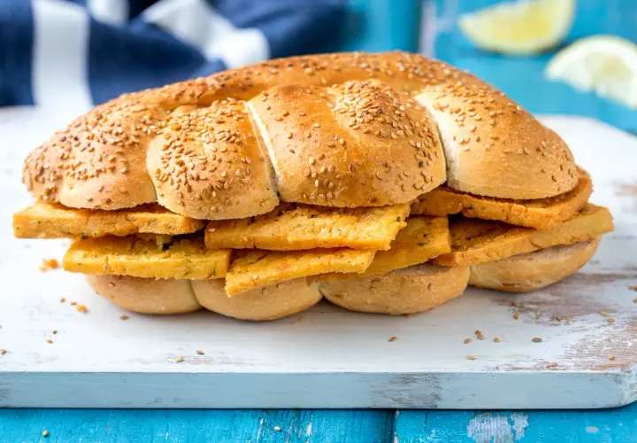 Pane morbido con semi di sesamo farcito con fette dorate di pane e panelle, un classico street food siciliano.