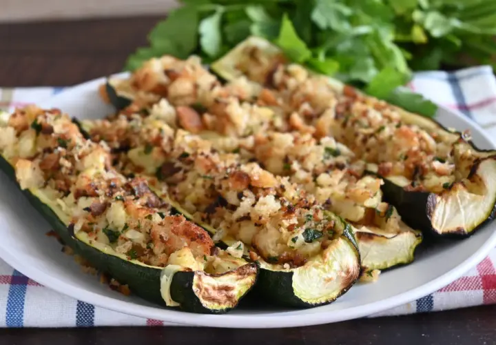 Zucchine ripiene velocissime, dorate e croccanti, servite su un piatto bianco con un contorno di prezzemolo fresco.